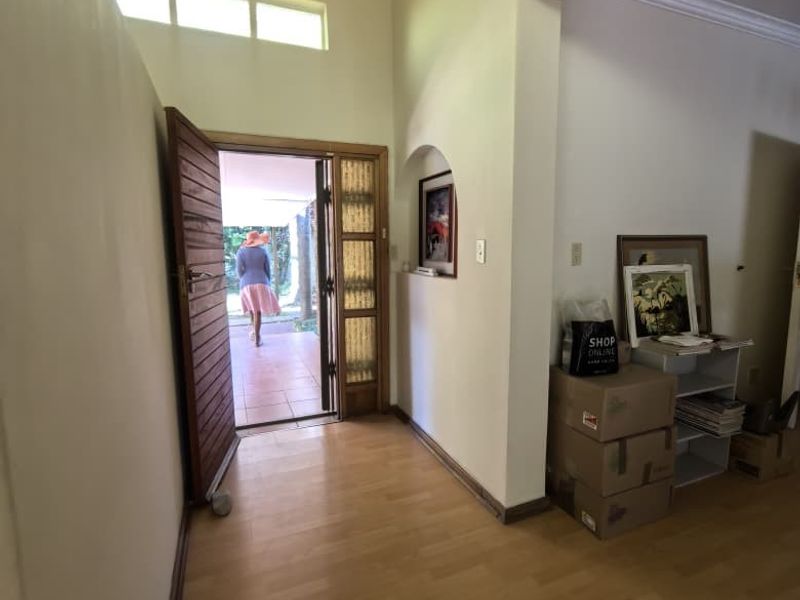 Entrance foyer featuring high vaulted ceilings, clerestory windows, and laminate flooring, leading directly to an outdoor patio area.