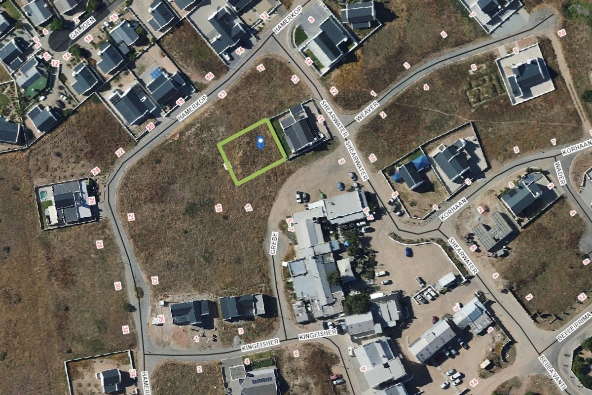 An aerial view of a vacant residential plot situated within a developed coastal estate, highlighting its location and surrounding neighborhood layout.
