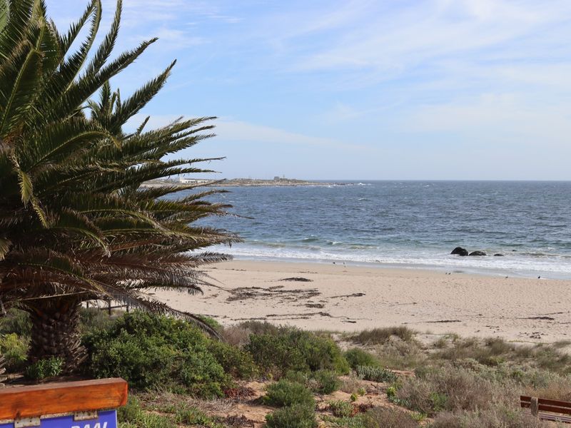 A scenic view of the sandy beach and ocean, showcasing the natural coastal landscape of the property.