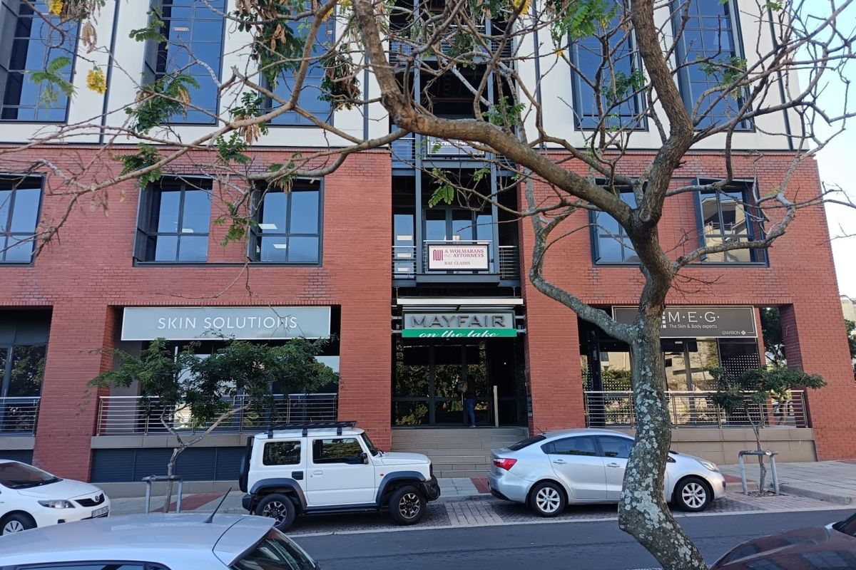 Front elevation of the Mayfair on the Lake office building, featuring a brick facade, large windows, and ground-floor commercial retail spaces.