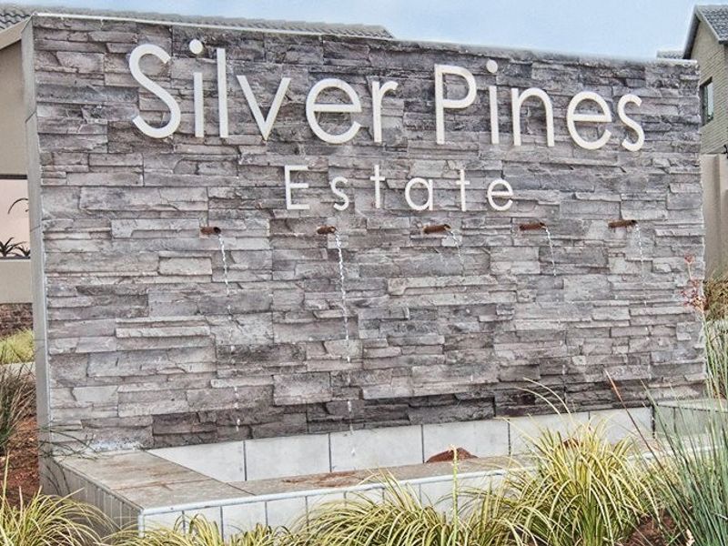 The entrance to Silver Pines Estate featuring a modern stone-clad feature wall with an integrated water fountain.
