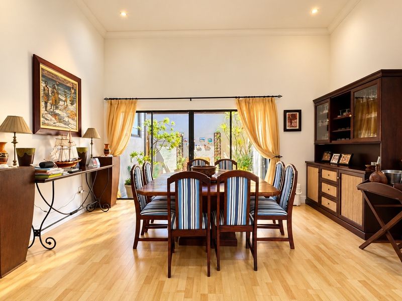 Spacious dining room featuring light laminate flooring, recessed lighting, and large sliding glass doors that provide natural light and access to the outdoor area.