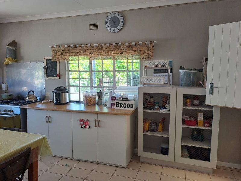A functional kitchen featuring built-in cabinetry, a gas stove, and tiled flooring, offering a practical layout with ample storage space.