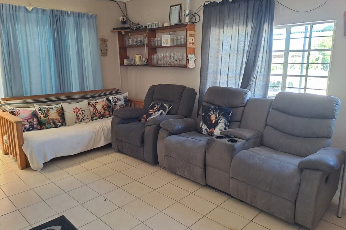 A living room area featuring tiled flooring and built-in wall shelving, currently showing signs of wear and exposed electrical wiring.
