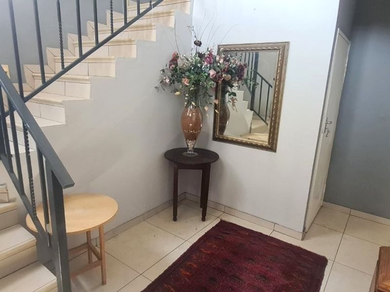 Entrance foyer featuring a tiled staircase with a metal balustrade and neutral wall finishes.