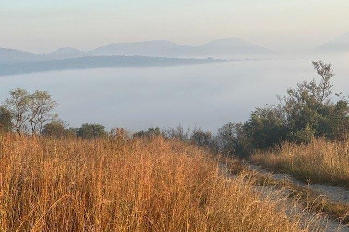 A scenic landscape view featuring rolling hills and misty valleys, showcasing the natural beauty of the surrounding environment.