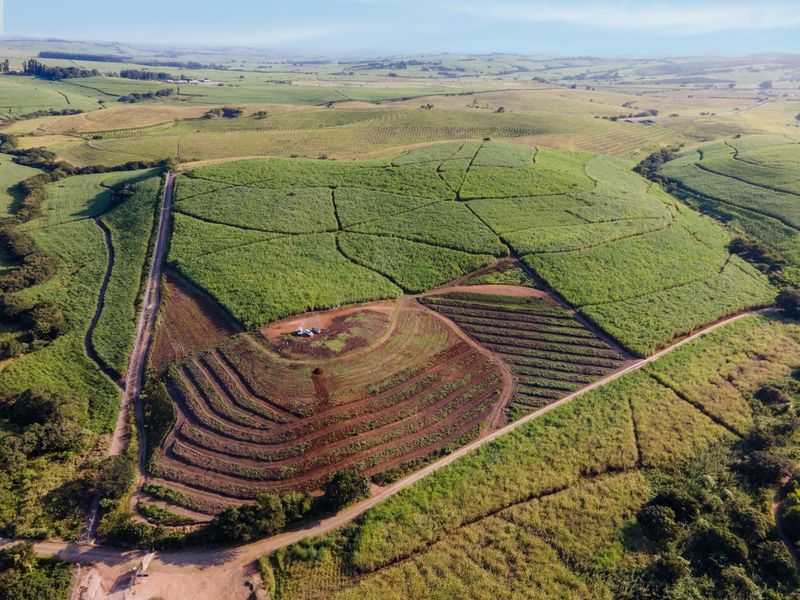 Aerial view of a large agricultural small holding featuring extensive terraced fields and established crop cultivation across rolling hills.