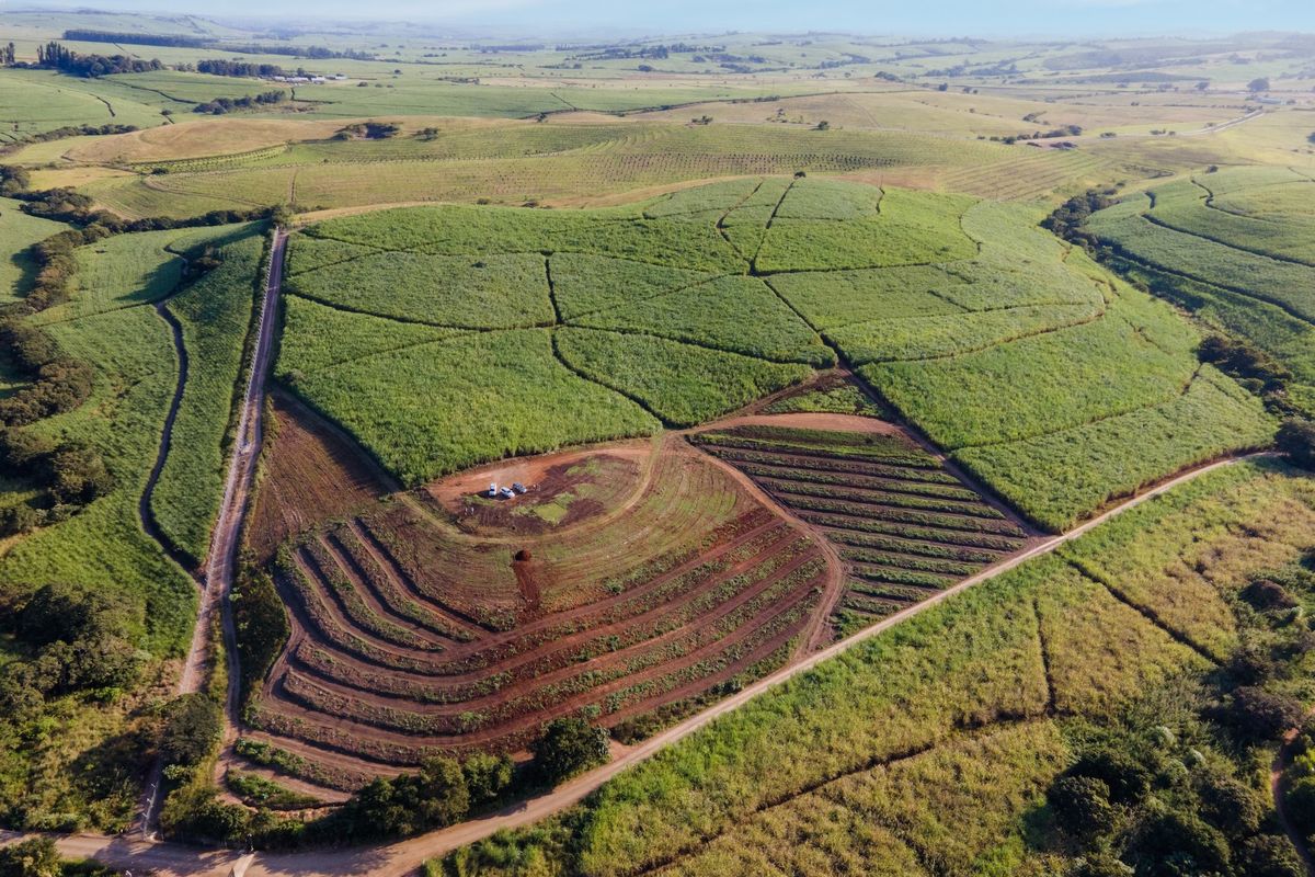 Aerial view of a large agricultural small holding featuring extensive terraced fields and established crop cultivation across rolling hills.