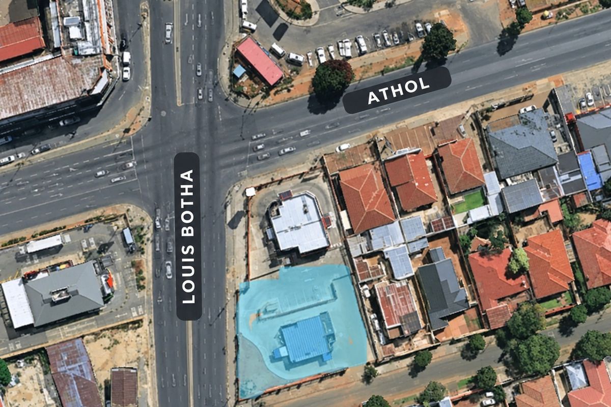 Aerial view of a commercial property located at a major intersection, featuring building structures and paved parking areas.