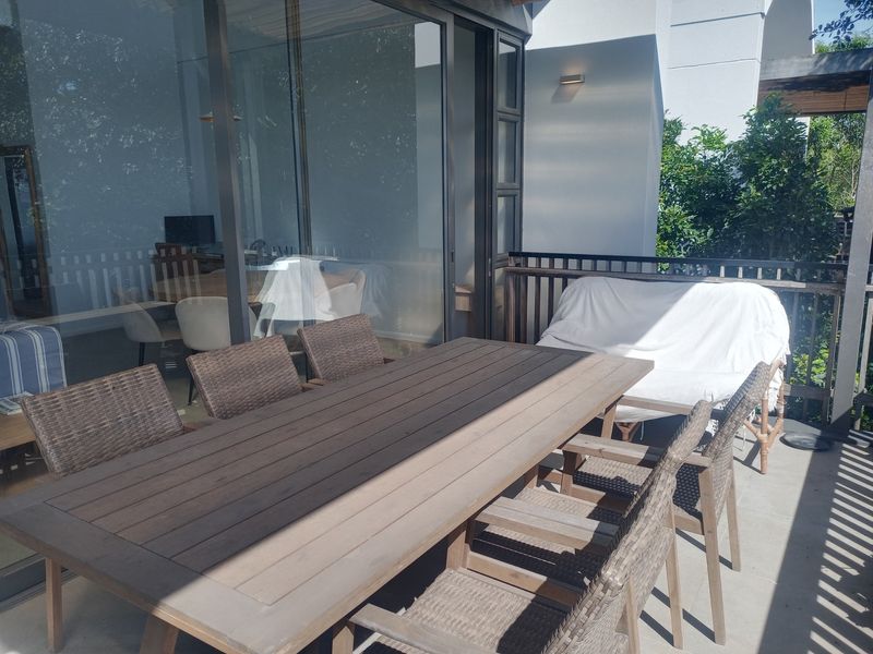 A spacious covered balcony featuring tiled flooring, a protective railing, and large sliding glass doors that provide seamless access to the interior living area.