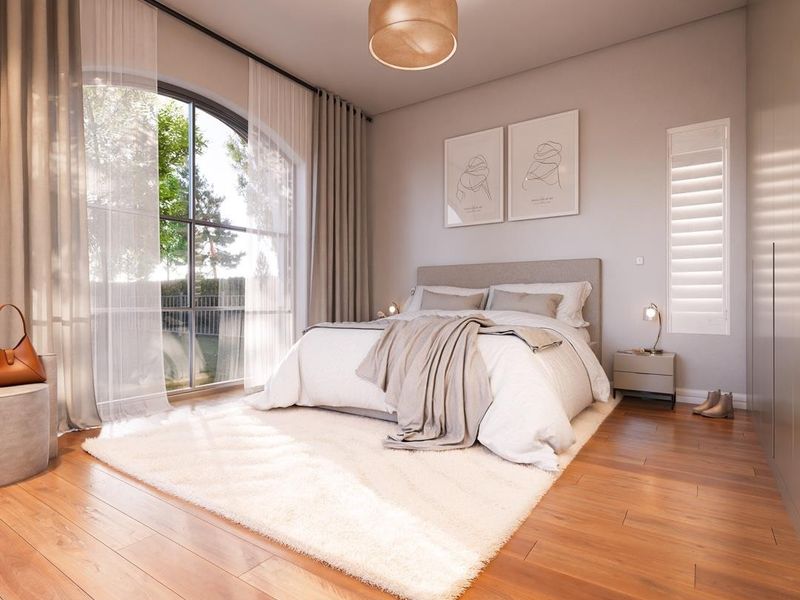 A bright and modern bedroom featuring elegant arched windows, warm hardwood flooring, and built-in storage solutions, creating a serene and inviting atmosphere.