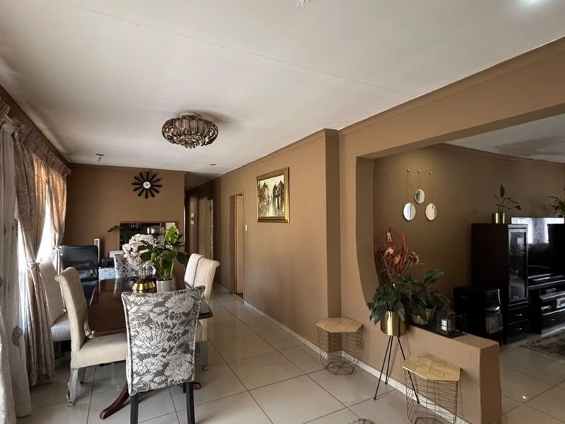 Open plan living and dining area featuring tiled flooring and a distinctive architectural archway connecting the two spaces.