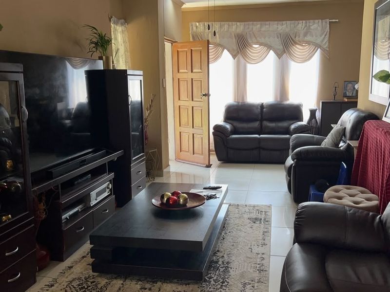 A comfortable living room featuring tiled flooring and direct access to the exterior through a timber door.