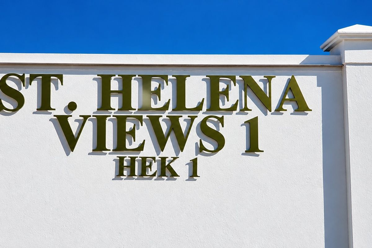 A clear view of the St. Helena Views 1 estate signage mounted on a well-maintained white boundary wall.