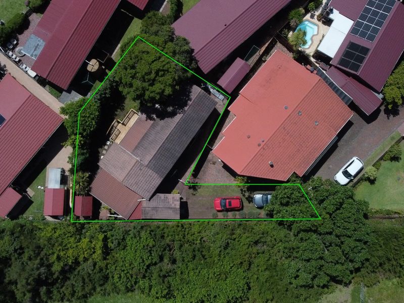 Aerial view of the property showing the roof structure, rear decking area, and driveway access within the highlighted boundary.