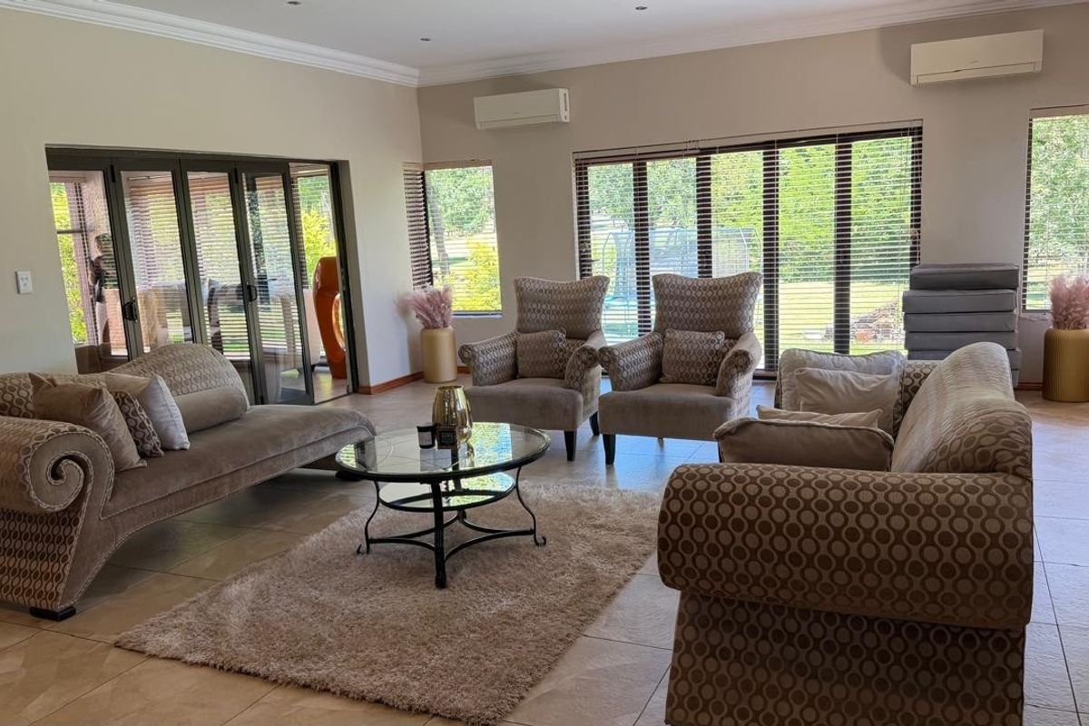 Spacious living room featuring tiled flooring, recessed lighting, dual split-system air conditioning units, and large aluminium sliding doors providing ample natural light.