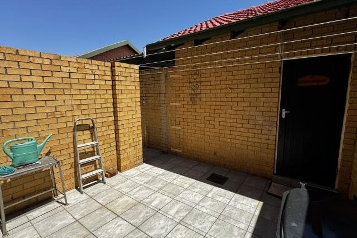 A private rear courtyard area featuring brick walls, tiled flooring, and a dedicated washing line, providing a functional outdoor utility space.