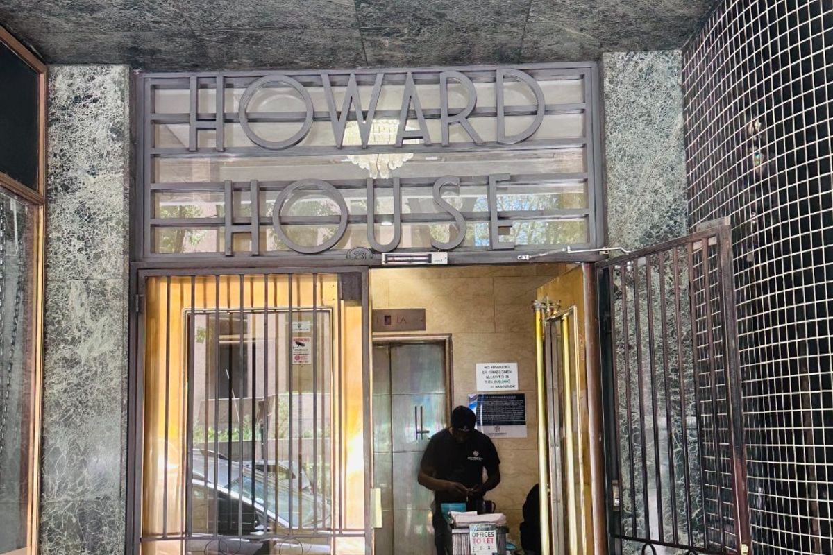 Main entrance to Howard House featuring marble wall cladding, secure metal gate, and a professional reception area.