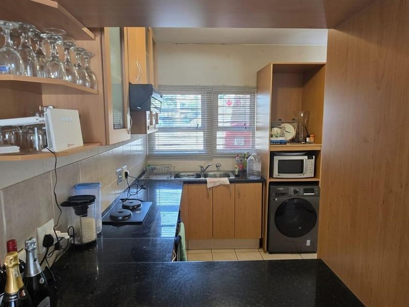 A functional kitchen featuring laminate cabinetry, granite countertops, a double basin sink, and built-in appliances, offering a practical layout for daily meal preparation.