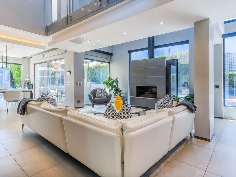 Spacious open-plan living area featuring modern tiled floors, a sleek built-in fireplace, and expansive glass doors leading to the outdoor space.