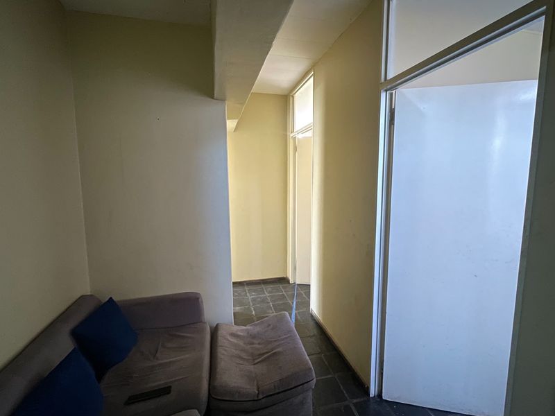 A functional hallway area featuring tiled flooring and neutral wall finishes, providing access to adjacent rooms within the apartment.