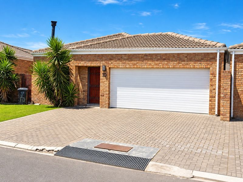 Front elevation of a brick house featuring a paved driveway, single garage, and secure entrance.