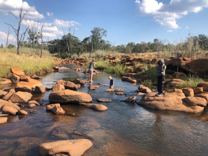 A scenic view of a natural stream flowing through rocky terrain on the property.