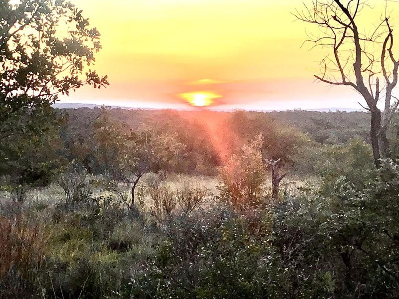 A scenic sunset view over the natural landscape of the vacant residential property.