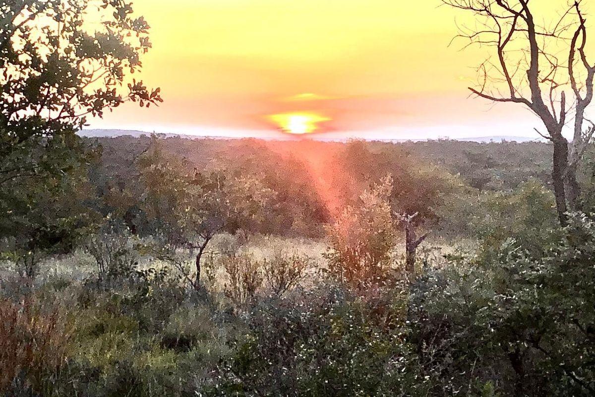 A scenic sunset view over the natural landscape of the vacant residential property.
