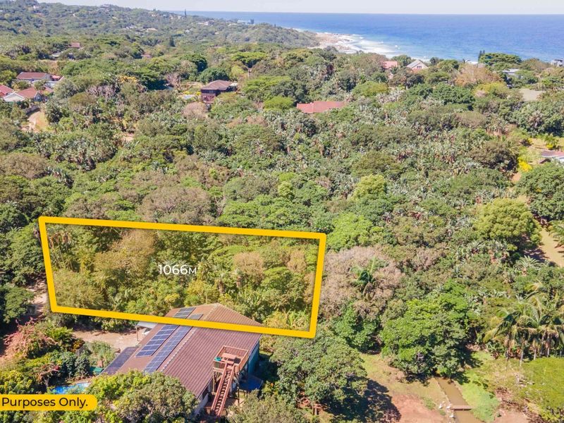 Aerial view of a residential plot featuring dense vegetation and a nearby coastal landscape, highlighting the property boundaries and surrounding area.