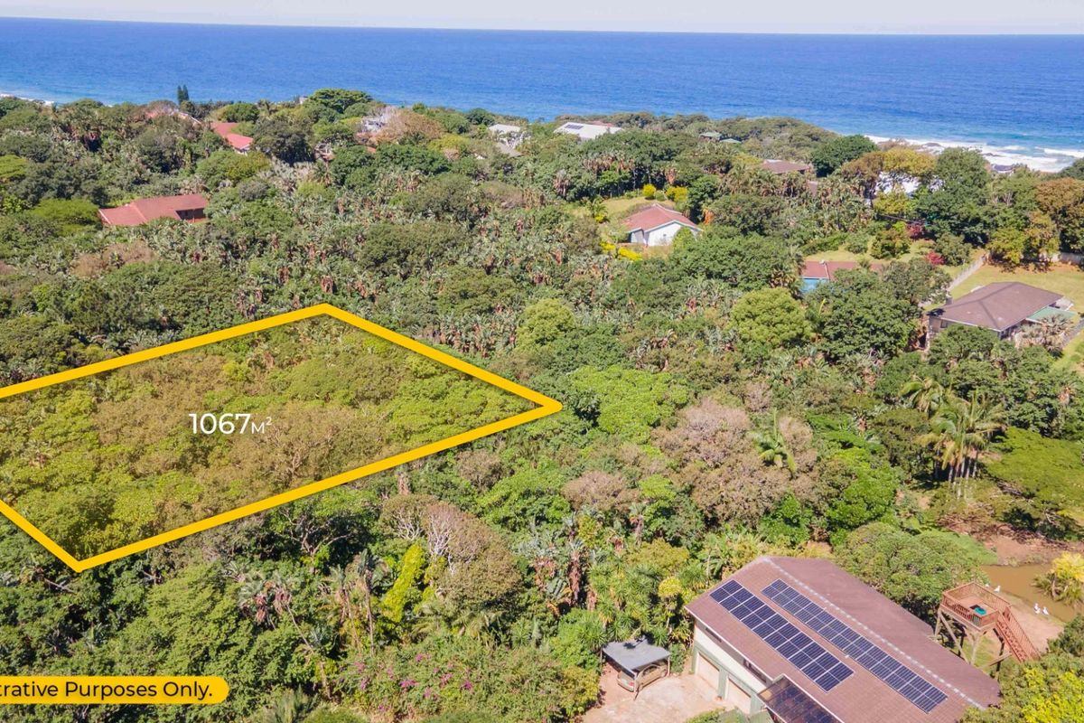 Aerial view of a 1067m2 vacant residential plot situated in a lush coastal area with ocean views.