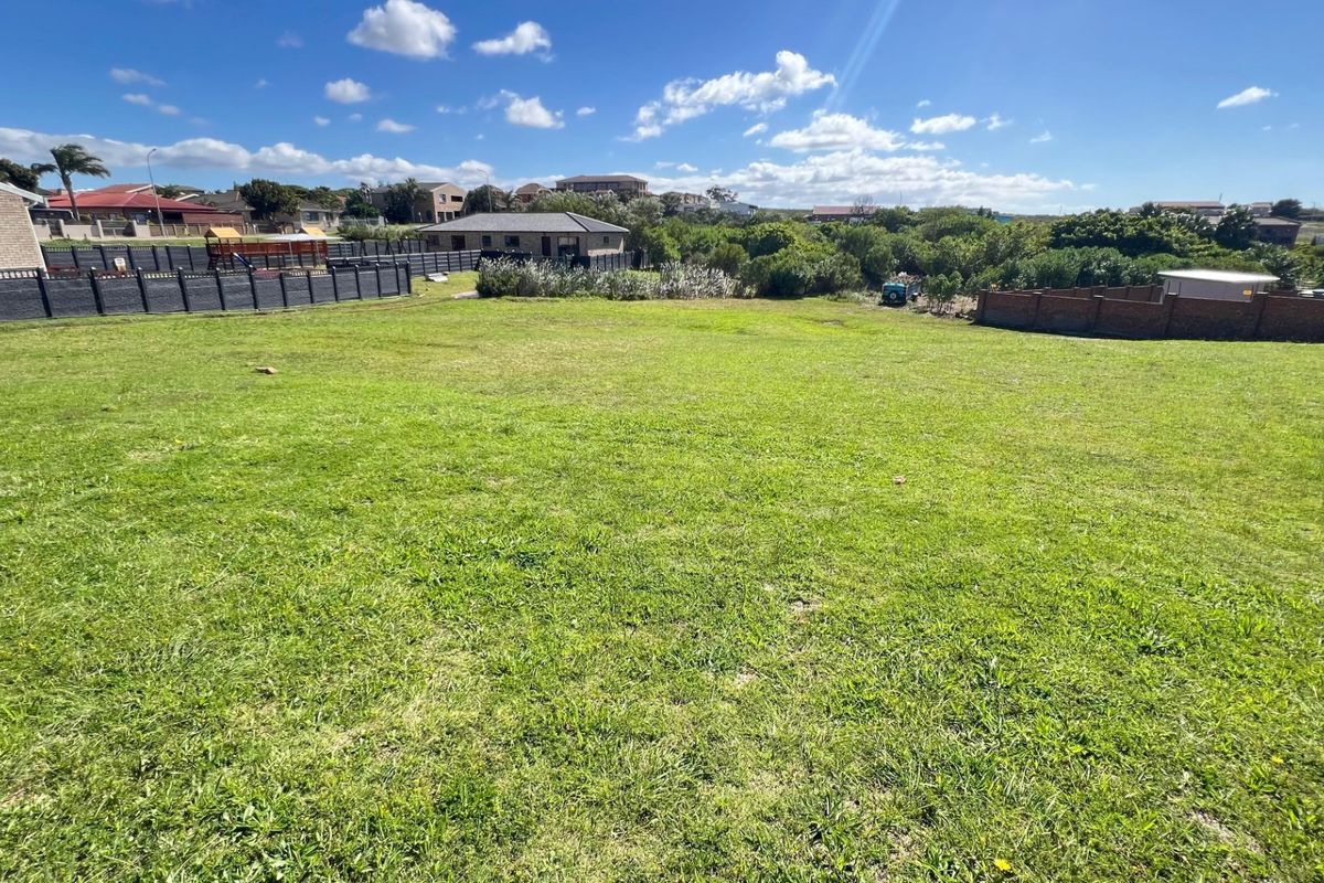 A spacious, level residential vacant plot featuring established grass cover and secure boundary fencing, situated within a developed neighborhood.