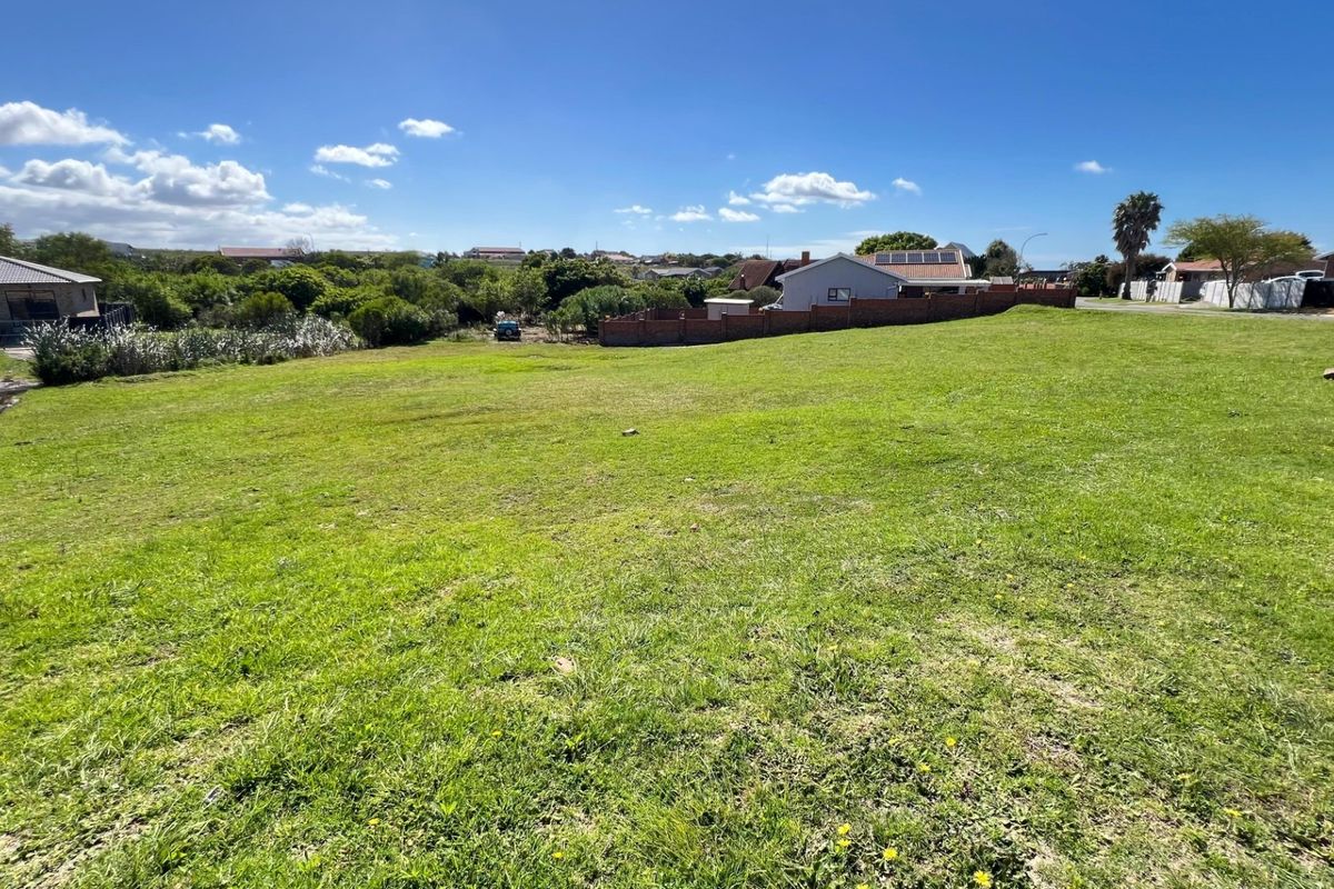 A spacious, level residential vacant plot featuring established grass cover and surrounding boundary walls in a quiet neighborhood setting.