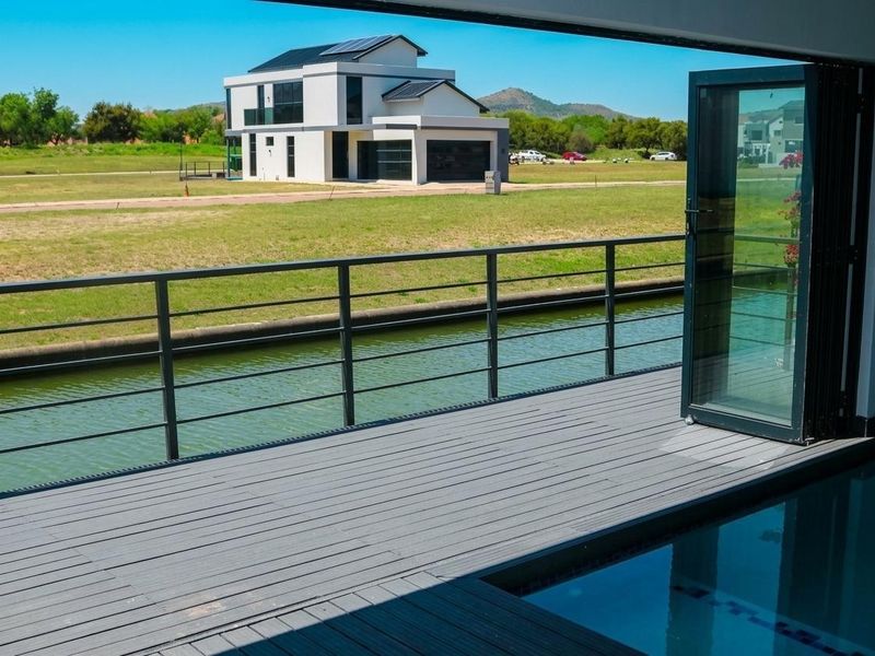 Modern outdoor patio featuring composite decking, a sleek metal balustrade, and a built-in plunge pool, offering direct access through folding glass doors.