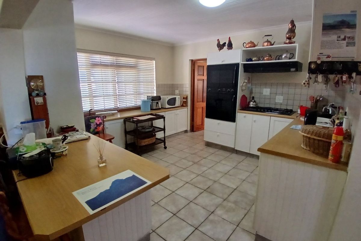 A functional kitchen featuring built-in cabinetry, a gas hob, an integrated oven, and tiled flooring with a breakfast counter area.
