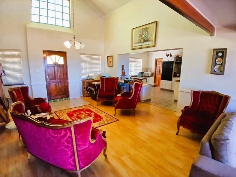 Spacious open-plan living area featuring vaulted ceilings, laminate flooring, and a seamless transition into the adjacent kitchen space.
