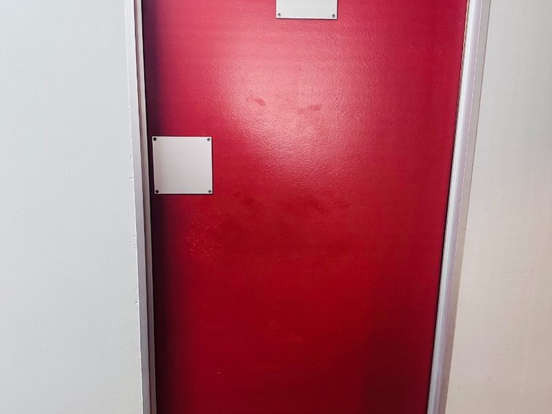 A red painted door indicating a female restroom facility within the office building.