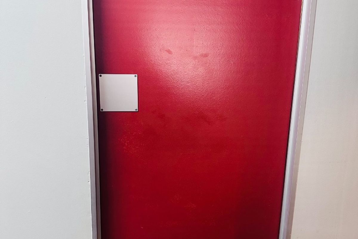 A red painted door indicating a female restroom facility within the office building.