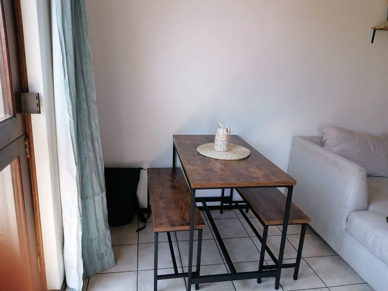 A living area featuring tiled flooring and a sliding glass door providing access to the exterior.