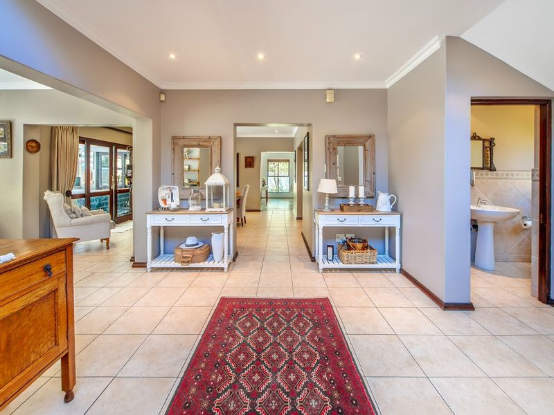 Spacious entrance hall featuring neutral tiled flooring, crown molding, recessed lighting, and direct access to an adjacent bathroom and living areas.