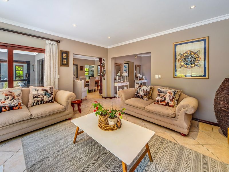 A spacious living room featuring tiled flooring, recessed downlighting, and large sliding glass doors that provide access to the outdoor area.