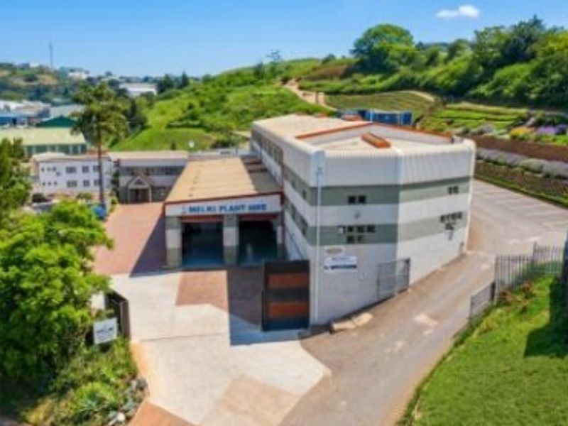 Aerial view of a commercial office and warehouse facility featuring paved access, loading bays, and surrounding landscaped grounds.