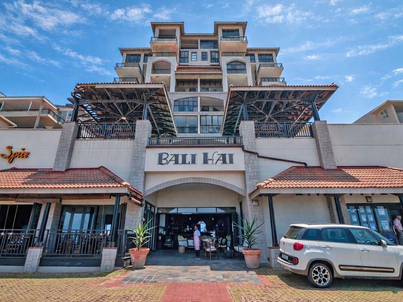 Front elevation of the Bali Hai apartment building featuring stone cladding, terracotta roof tiles, and multiple levels of balconies.