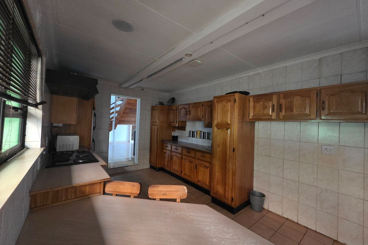 A functional kitchen featuring traditional wooden cabinetry, tiled backsplash, and built-in cooking appliances, offering a classic layout with potential for modern updates.