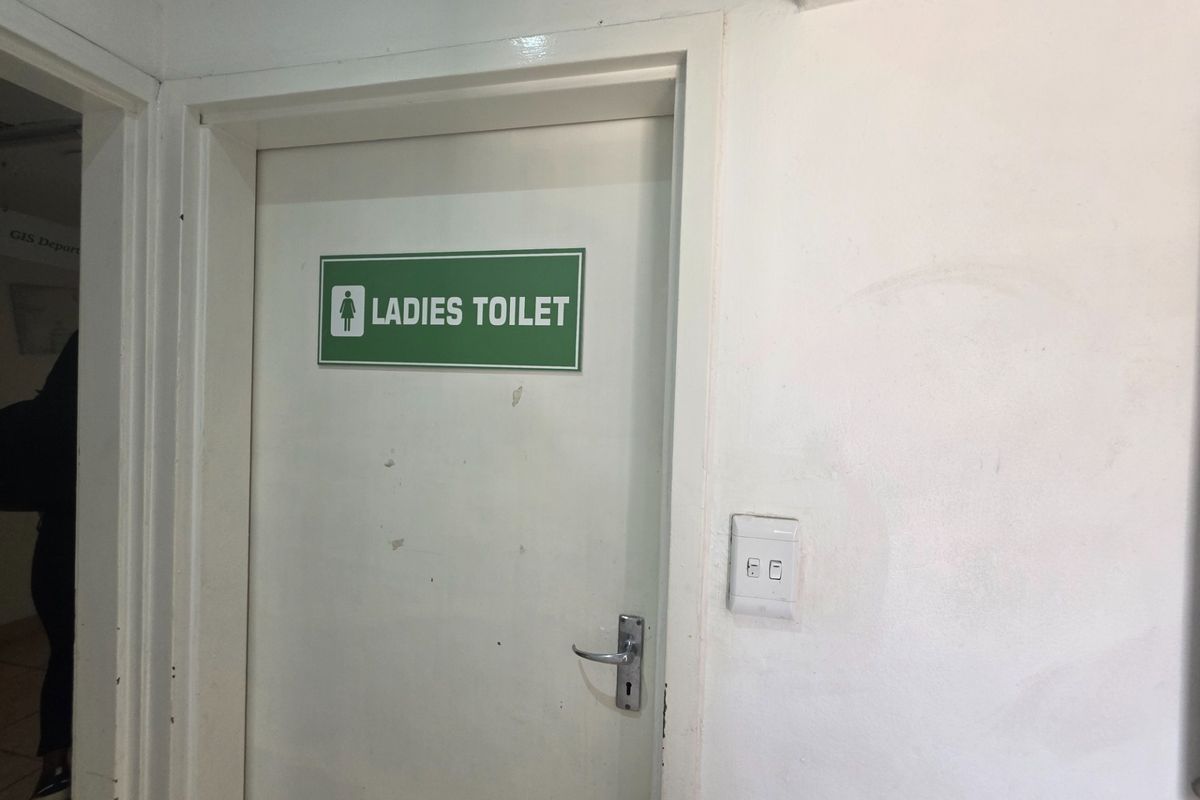 A view of a ladies toilet door with signage in an office environment.
