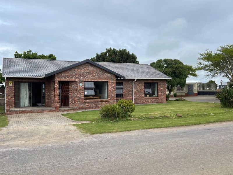 A well-maintained single-story face brick house featuring a tiled roof, paved driveway, and established front garden in a quiet residential setting.
