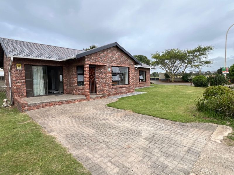 A well-maintained face brick house featuring a paved driveway, covered porch, and established garden, presenting a classic and durable exterior aesthetic.