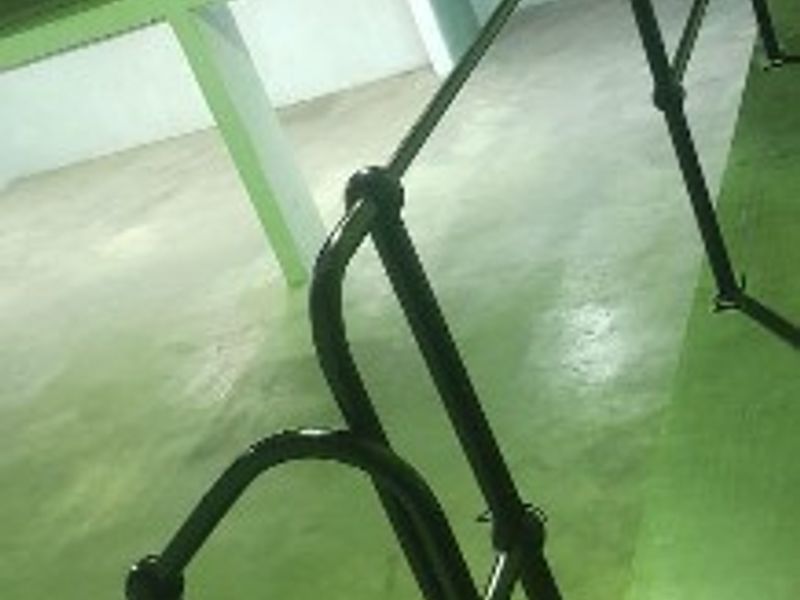 Spacious industrial utility area featuring a mezzanine level, metal staircase, and safety railings, suitable for storage or workshop use.