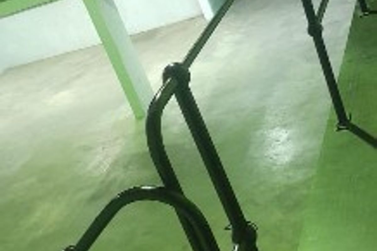 Spacious industrial utility area featuring a mezzanine level, metal staircase, and safety railings, suitable for storage or workshop use.
