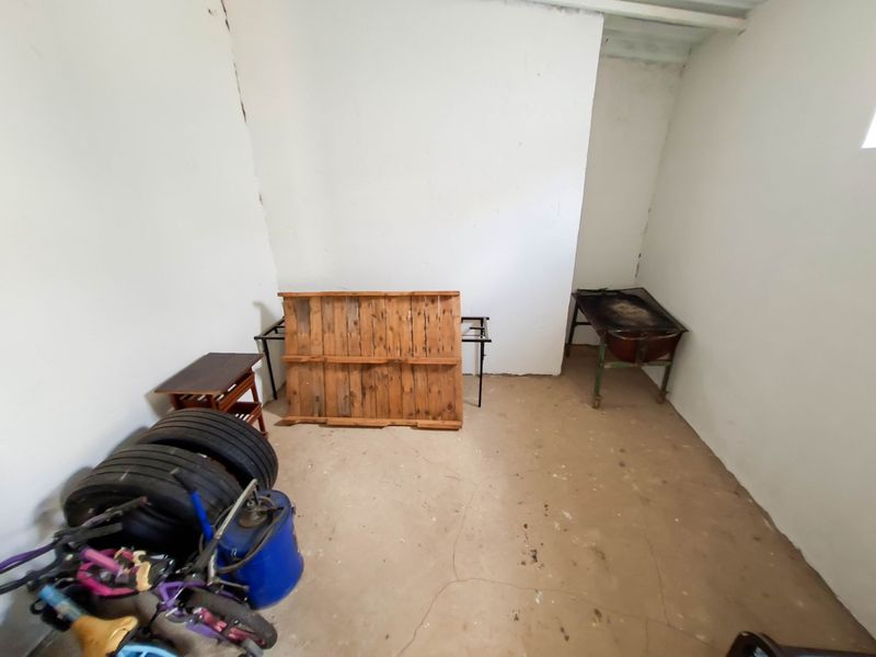 A basic utility or storage space featuring concrete flooring and unfinished walls, suitable for conversion or functional storage use.